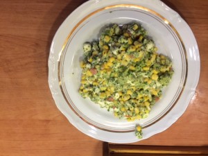 Na białym okrągłym talerzu ułożona zielona sałatka z brokułem i Mozzarellą