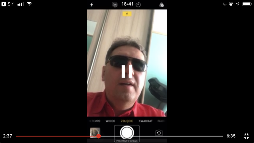 Zrzut ekranu z iPhone - Kadr z nagrania. Aplikacja Aparat i twarz Piotra widoczna w oknie podglądu.