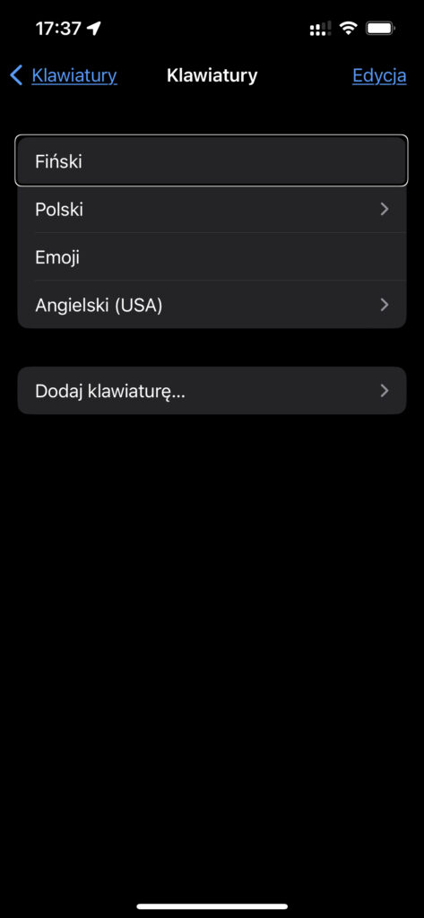 Zrzut ekranu ustawień iPhone z listą dodanych klawiatur. Na liście widnieją klawiatury Fińska, Polska, Angielska USA, oraz Emoji.