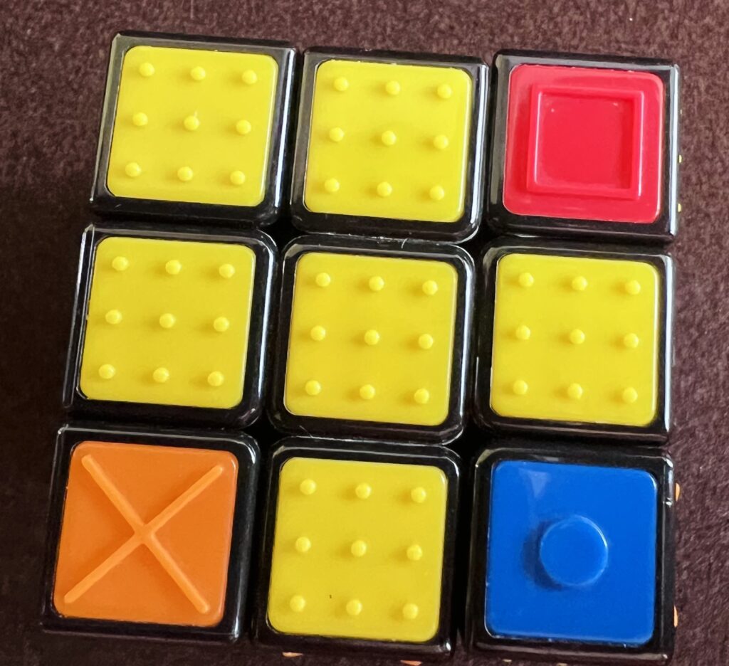 Widok żółtej ściany kostki Rubika. Prawidłowo ułożony jest jedynie lewy górny róg.
